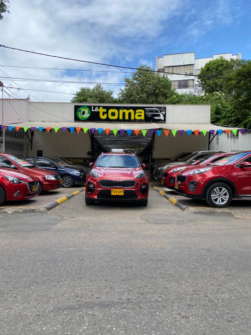 Vehículos rojos y SUV exhibidos en el patio de La Toma